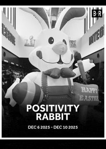 a black and white photo of an inflatable easter bunny holding a sign that says " happy easter "