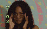 a woman wearing sunglasses with the numbers v103 on the bottom of her face