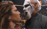 a woman is kissing a man with a beard in front of a crowd with the hashtag wrestlingcovers on the bottom