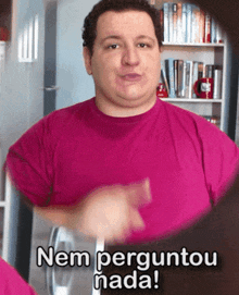 a man in a pink shirt says " nem perguntou nada " in sign language