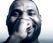 a man with a beard is laughing with his hand on his mouth