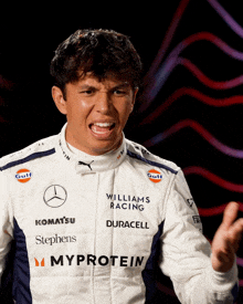 a man in a williams racing uniform makes a face