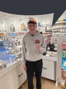 a man holding a lollipop in front of a store with a sign that says ' a place like home ' on the wall