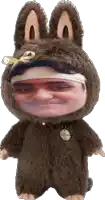 a stuffed animal with a man 's face on it is wearing bunny ears