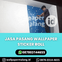 a man is applying wallpaper to a wall with a sticker roll