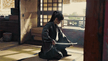 a man kneeling down holding a sword in a room