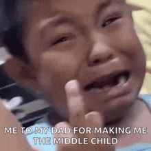 a little boy is crying and giving the middle finger .