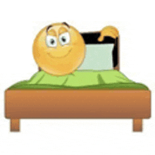 a smiley face is laying in a bed with a green blanket .