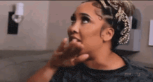 a woman is making a funny face with her hand on her face .