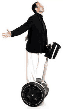 a man in a suit is riding a segway with his arms outstretched .