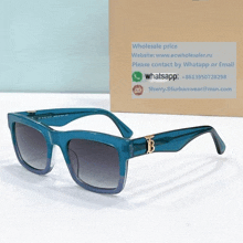 a pair of blue sunglasses sits next to a box that says wholesale price on it