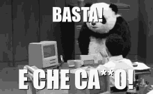 a man sitting at a desk with a panda mascot behind him that says basta e che ca * o