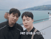 a couple of men standing next to each other with korean writing on the bottom right