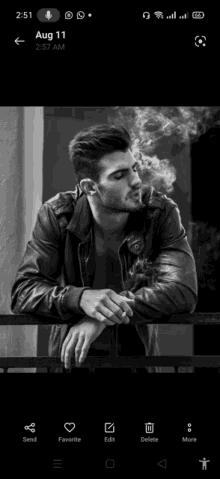 a man in a leather jacket is smoking a cigarette while leaning on a railing .