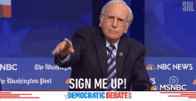 a man in a suit and tie stands in front of a sign that says sign me up democratic debate