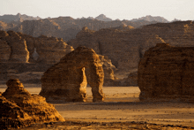 a desert landscape with a large rock formation in the middle