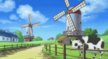 a cow is standing in front of a windmill in a field