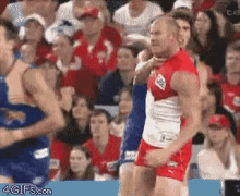 a man in a red and white jersey with the word sydney on it stands in front of a crowd