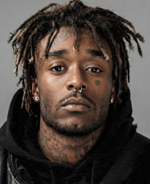 a man with dreadlocks and tattoos on his face