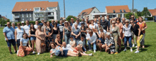 a large group of people posing for a picture in a field