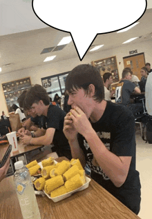 a boy eating corn on the cob in a cafeteria