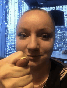 a close up of a woman 's face with a ring on her finger .