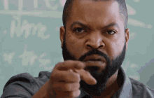ice cube with a beard is pointing at the camera with his finger .