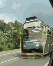 a white car is being loaded on a truck with a license plate that says nz - tz - 00