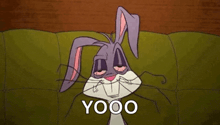 bugs bunny from looney tunes is laying on a couch with his eyes closed and smiling .