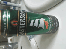 a green can of amsterdam beer sits on a bathroom counter