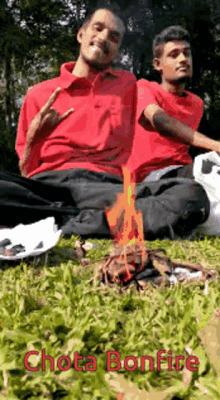 two men in red shirts are sitting in the grass with a fire in the background and the words chota bonfire on the bottom