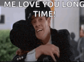 a man in a suit and hat is hugging a woman in a hat .