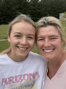 two women posing for a picture with one wearing a shirt that says arizona on it