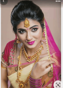 a woman wearing a pink veil and gold jewelry with a pink lip