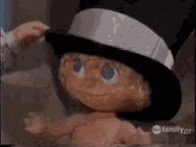 a baby doll wearing a top hat is on abc family channel