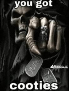 a grim reaper is pointing at a dog tag with a skull ring on his finger .