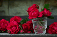 a vase filled with red roses sits on a table