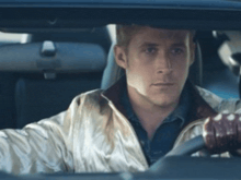 a man in a white jacket is driving a car and looking at the camera