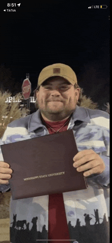 a man holding a diploma that says mississippi state university