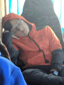 a person wearing a red jacket with the word north face on it sleeping