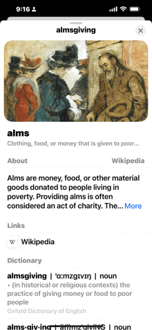 a phone screen shows a dictionary definition of alms