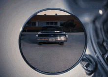 a car in a parking lot is reflected in a rear view mirror with a license plate that says nc 88