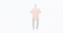 a man in an orange shirt and black pants is dancing .