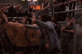 a woman is standing next to a donkey in front of a crowd in front of a sign that says club