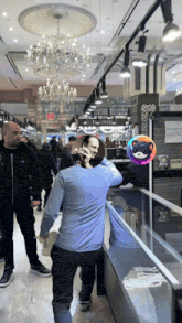 a man in a blue shirt is standing in front of a display case with a sign that says exit