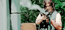 a man is holding a gun in his right hand and shooting it .