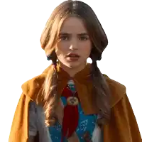 a girl wearing a cape and a red scarf looks at the camera