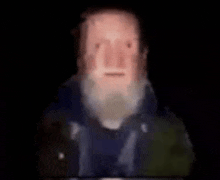 a blurry picture of a man with a beard and a blue jacket .