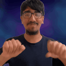a man with glasses and a beard giving a thumbs down sign