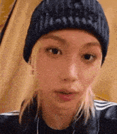 a close up of a person wearing a black beanie and headphones .